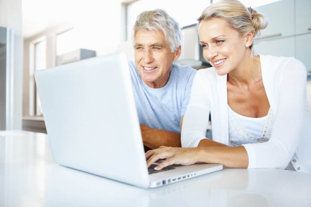 Senior man and mature woman using a laptop in the kitchen